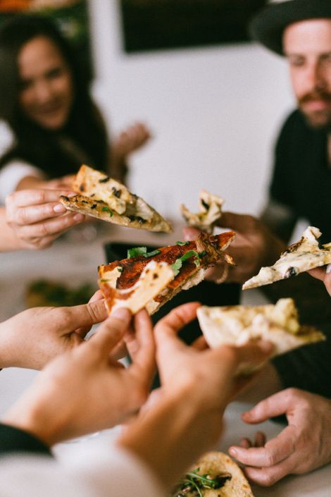 Venner som "skåler" med pizza